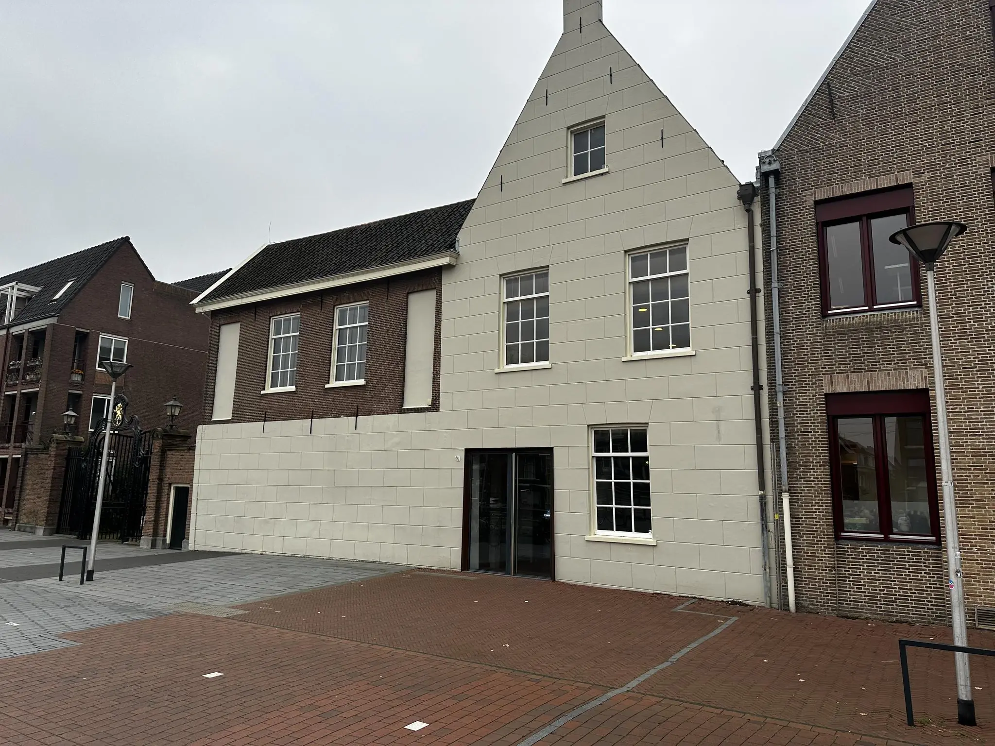 Voorgevel van een historisch gebouw aan het Sint-Agathaplein met gemetselde en wit gepleisterde gevels.